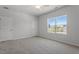 Spacious bedroom with plush carpet, ceiling fan, and a large window overlooking the outdoors at 103 Central Townes Way # 297, Raleigh, NC 27603