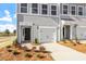 Charming townhome exterior featuring gray siding, a one-car garage, and neatly landscaped front yard at 103 Central Townes Way # 297, Raleigh, NC 27603