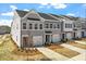 Townhome exterior showcasing gray siding, a single-car garage, a manicured lawn, and a private driveway at 103 Central Townes Way # 297, Raleigh, NC 27603