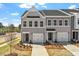 Townhome exterior displaying gray siding, a single car garage, landscaped front yard, and private driveway at 103 Central Townes Way # 297, Raleigh, NC 27603