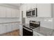 Modern kitchen featuring white cabinets, stainless steel appliances, and granite countertops at 103 Central Townes Way # 297, Raleigh, NC 27603