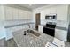 Well-lit kitchen featuring white cabinetry, stainless steel appliances, and granite countertops at 103 Central Townes Way # 297, Raleigh, NC 27603