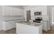 Modern kitchen boasts white cabinets, stainless steel appliances, granite countertops, and an island with a sink at 103 Central Townes Way # 297, Raleigh, NC 27603