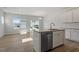 Open-concept kitchen with stainless steel dishwasher, island with sink and pendant lighting and wood flooring at 103 Central Townes Way # 297, Raleigh, NC 27603
