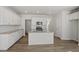 Modern kitchen boasts white cabinets, stainless steel appliances, granite countertops, a kitchen island and wood floors at 103 Central Townes Way # 297, Raleigh, NC 27603