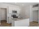 Modern kitchen with white cabinets, stainless steel appliances, granite countertops, an island with a sink, and wood flooring at 103 Central Townes Way # 297, Raleigh, NC 27603