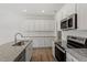 Modern kitchen featuring white cabinets, stainless steel appliances, and granite countertops at 103 Central Townes Way # 297, Raleigh, NC 27603