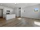 Open-concept living room with light-colored walls and wood-look flooring adjacent to the kitchen with a white island at 103 Central Townes Way # 297, Raleigh, NC 27603
