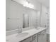 Bathroom featuring double sinks, quartz countertop, and shower with white tile surround at 104 Central Townes Way # 296, Raleigh, NC 27603