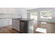 Kitchen with island and granite countertop, stainless dishwasher, and wood-look flooring open to the living area at 104 Central Townes Way # 296, Raleigh, NC 27603