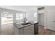 Kitchen with island and granite countertop, stainless dishwasher, and wood-look flooring open to the living area at 104 Central Townes Way # 296, Raleigh, NC 27603