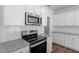 Bright kitchen features white cabinets, granite countertops, subway tile backsplash, and stainless appliances at 104 Central Townes Way # 296, Raleigh, NC 27603