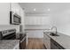 Bright kitchen features white cabinets, granite countertops, stainless appliances, and wood-look flooring at 104 Central Townes Way # 296, Raleigh, NC 27603