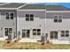 Rear exterior view of the townhomes featuring patios, sliding glass doors, and neat landscaping at 107 Central Townes Way # 298, Raleigh, NC 27603