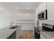 Modern kitchen features stainless appliances, white cabinets, and granite countertops at 107 Central Townes Way # 298, Raleigh, NC 27603
