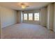 Spacious bedroom with neutral carpet, ceiling fan and abundant natural light from three windows at 111 Central Townes Way # 299, Raleigh, NC 27603
