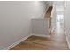 Inviting hallway with wood-look flooring, leading to a carpeted staircase and bright, modern kitchen at 111 Central Townes Way # 299, Raleigh, NC 27603