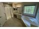 Bright bathroom featuring a walk-in shower, soaking tub beneath a large window, and granite countertops at 112 Gingergate Dr, Cary, NC 27519