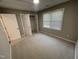 Clean bedroom with neutral paint, new carpet, a window, and closet with door removed at 112 Gingergate Dr, Cary, NC 27519