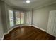 Bright bedroom featuring hardwood floors, neutral walls, and natural light from large windows at 112 Gingergate Dr, Cary, NC 27519