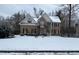 Two-story brick home with dormers, shutters, and snowy front yard at 112 Gingergate Dr, Cary, NC 27519