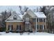 Brick home with dormers, shutters, and front yard covered with snow at 112 Gingergate Dr, Cary, NC 27519