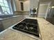 Gourmet kitchen with stainless steel appliances and a large island with a built-in cooktop at 112 Gingergate Dr, Cary, NC 27519