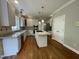 Bright kitchen featuring white cabinets, granite countertops, stainless steel appliances, and hardwood flooring at 112 Gingergate Dr, Cary, NC 27519
