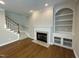 Living room featuring a fireplace, built-in shelves, and hardwood flooring at 112 Gingergate Dr, Cary, NC 27519
