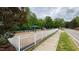 Community playground area featuring a swing set, slide, and white picket fence surrounding a wood chip safety area at 112 Gingergate Dr, Cary, NC 27519