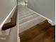 Carpeted staircase with wood trim and railing, adding warmth and elegance to the home's interior at 112 Gingergate Dr, Cary, NC 27519