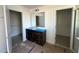 Bathroom with dark cabinets, dual walk-in closets, and a large mirror above the vanity at 1125 Channel Drop Lp, Zebulon, NC 27597