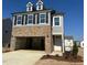 Beautiful new construction home with two-car garage, brick accents, gray siding and dormer windows at 1125 Channel Drop Lp, Zebulon, NC 27597