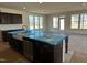 Spacious kitchen with large island, stainless steel appliances, dark cabinetry, and plenty of natural light at 1125 Channel Drop Lp, Zebulon, NC 27597