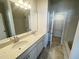 Bathroom featuring double sinks, quartz countertops, large mirror, and white shaker cabinets at 115 Central Townes Way # 300, Raleigh, NC 27603