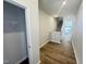 Inviting hallway features hardwood floors, staircase, closet and leads into the open-concept living area at 115 Central Townes Way # 300, Raleigh, NC 27603