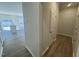 The home's hallway leads to open-concept living, dining, and kitchen areas featuring vinyl flooring at 115 Central Townes Way # 300, Raleigh, NC 27603