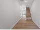 A hallway featuring hardwood floors and a carpeted staircase leads to the upper level at 116 Fideaux Blvd # 258, Raleigh, NC 27603