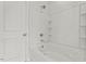 Clean, white bathroom with a tub and shower combination with tiled walls and built-in shelving at 119 Central Townes Way # 301, Raleigh, NC 27603