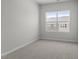Neutral bedroom featuring a plush carpet, natural lighting, and a view of the neighborhood at 119 Central Townes Way # 301, Raleigh, NC 27603