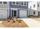 Exterior view of townhome featuring garage, front door, and manicured lawn at 119 Central Townes Way # 301, Raleigh, NC 27603