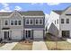 Charming gray and blue townhome featuring a front-entry garage and well manicured lawn at 119 Central Townes Way # 301, Raleigh, NC 27603