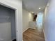 Bright hallway featuring hardwood floors, neutral walls, staircase, and closet with shelving at 119 Central Townes Way # 301, Raleigh, NC 27603