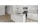 Modern kitchen with white cabinets, granite countertop island, and stainless steel microwave at 119 Central Townes Way # 301, Raleigh, NC 27603