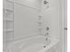 Bathroom featuring a tub with white tiled walls and built-in shelves for storage at 128 Fideaux Blvd # 255, Raleigh, NC 27603