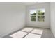 Sunlit bedroom with a large window, neutral carpet, and blank white walls at 136 Fideaux Blvd # 253, Raleigh, NC 27603