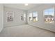Spacious bedroom features neutral carpet, a ceiling fan, and plenty of natural light from large windows at 136 Fideaux Blvd # 253, Raleigh, NC 27603