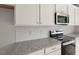 Close up view of kitchen featuring stainless steel appliances, white subway tile, and granite countertops at 136 Fideaux Blvd # 253, Raleigh, NC 27603