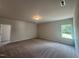 A spacious bedroom has neutral carpet, walls, one window, and an overhead light at 142 Vega Loop, Sanford, NC 27330
