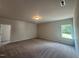 A spacious bedroom has neutral carpet, walls, one window, and an overhead light at 142 Vega Loop, Sanford, NC 27330